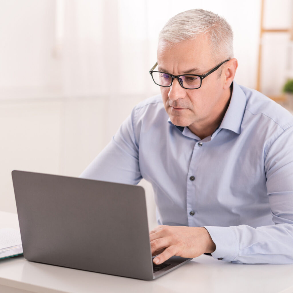 Man with eyeglasses on using computer.